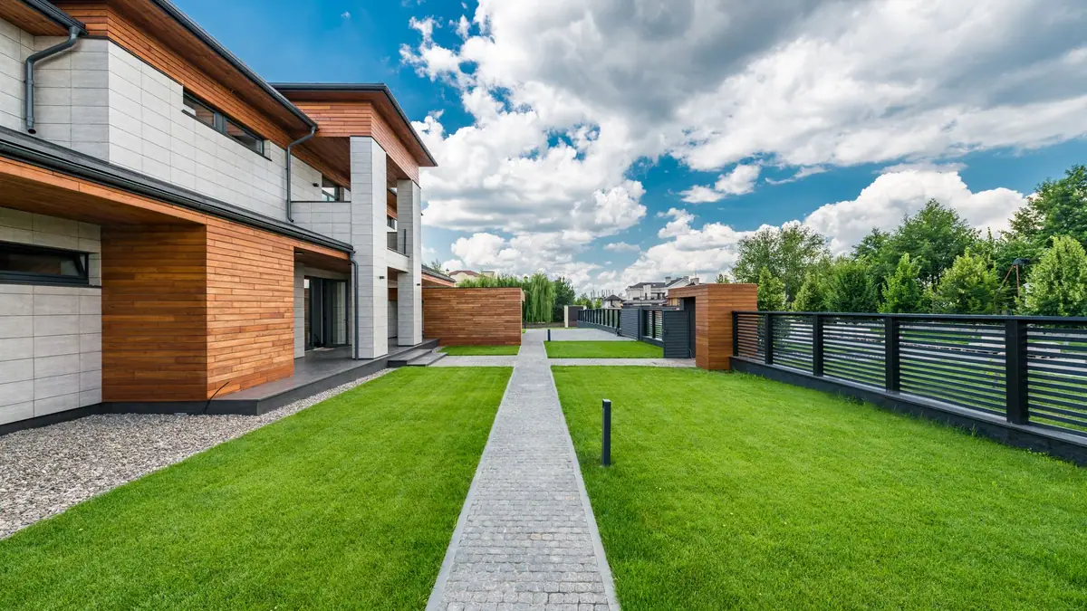 Modern home with a paved path and lawn along the side yard