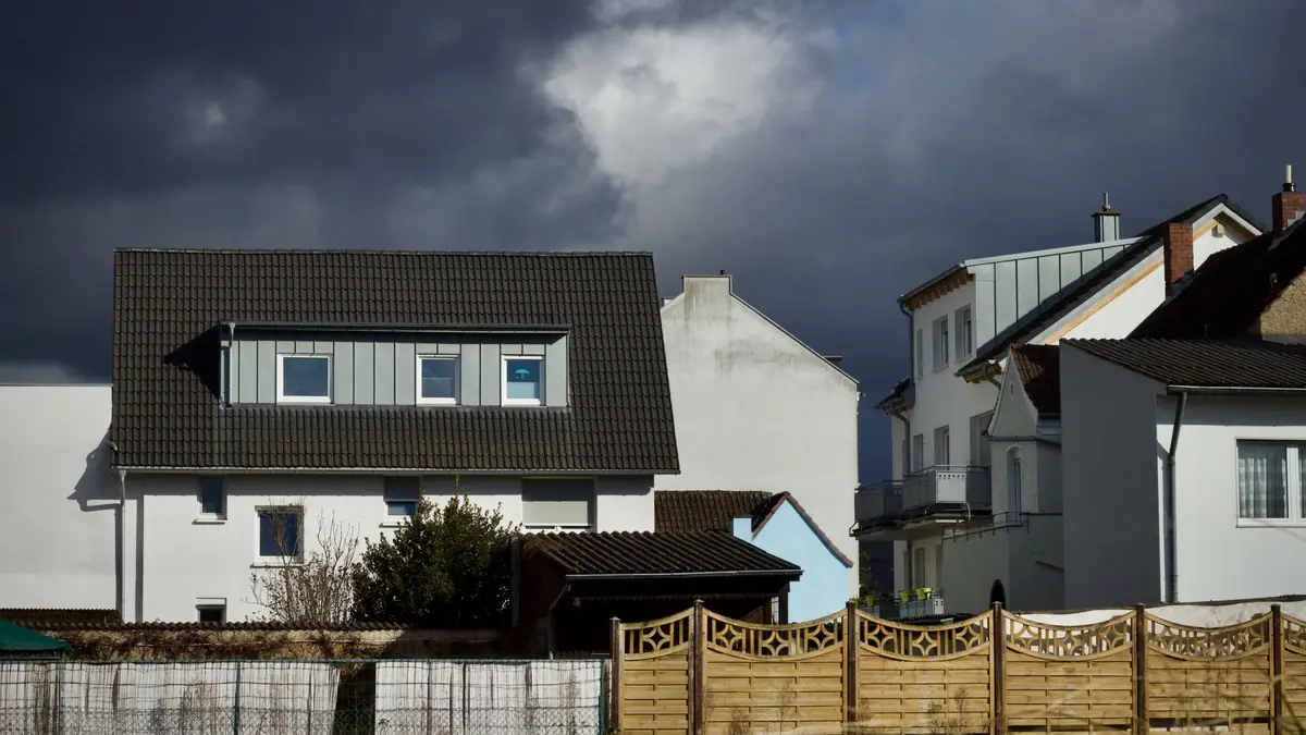 Dark storm clouds over houses with pitched roofs