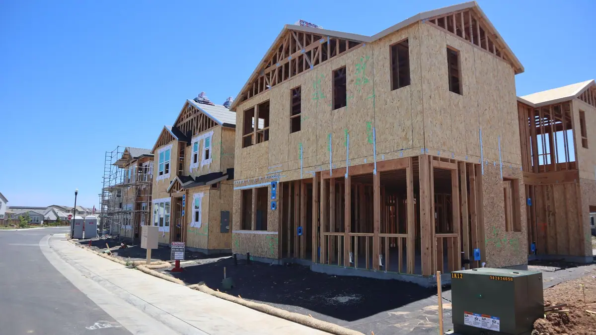Wood-framed new homes under construction along a street