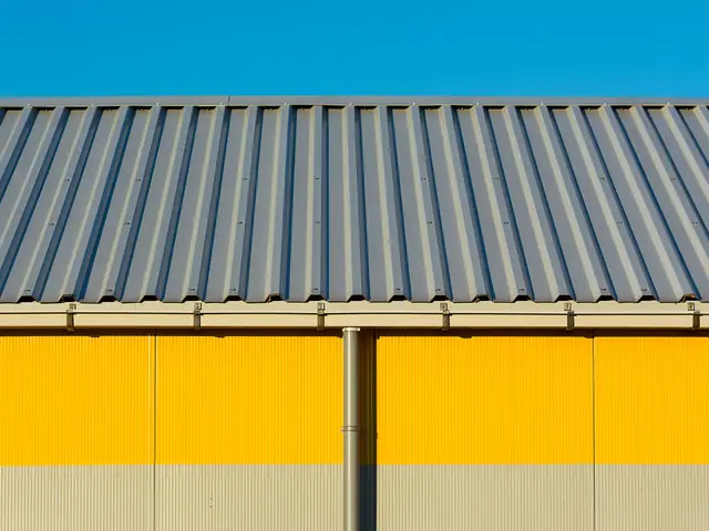 Yellow commercial building with a gutter and downspout under a blue sky