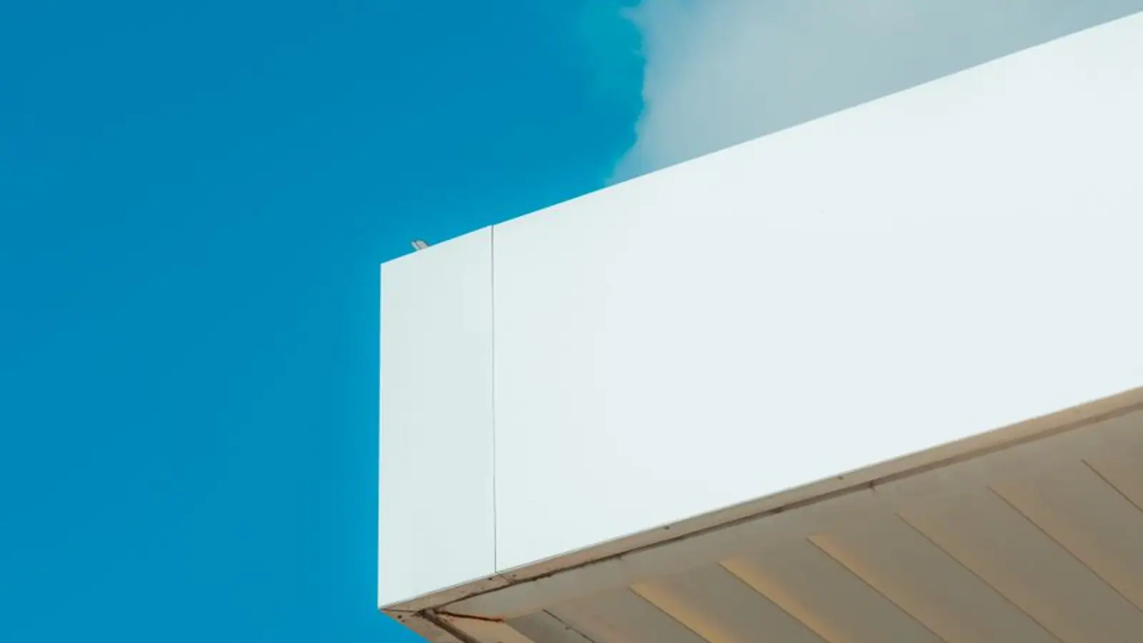 White fascia and soffit overhang against a blue sky