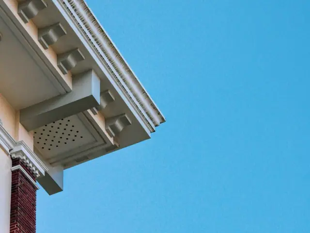 White fascia and soffit overhang against a blue sky