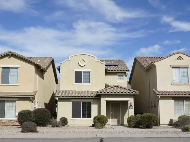 Two-story stucco homes with tile roofs and gutters in a Florida suburb